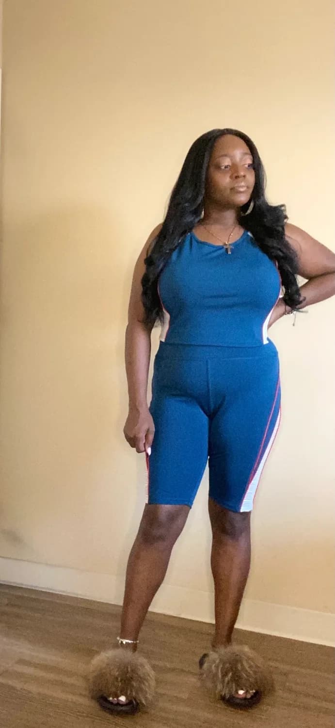 Woman in blue sleeveless top and biker shorts with fluffy slippers