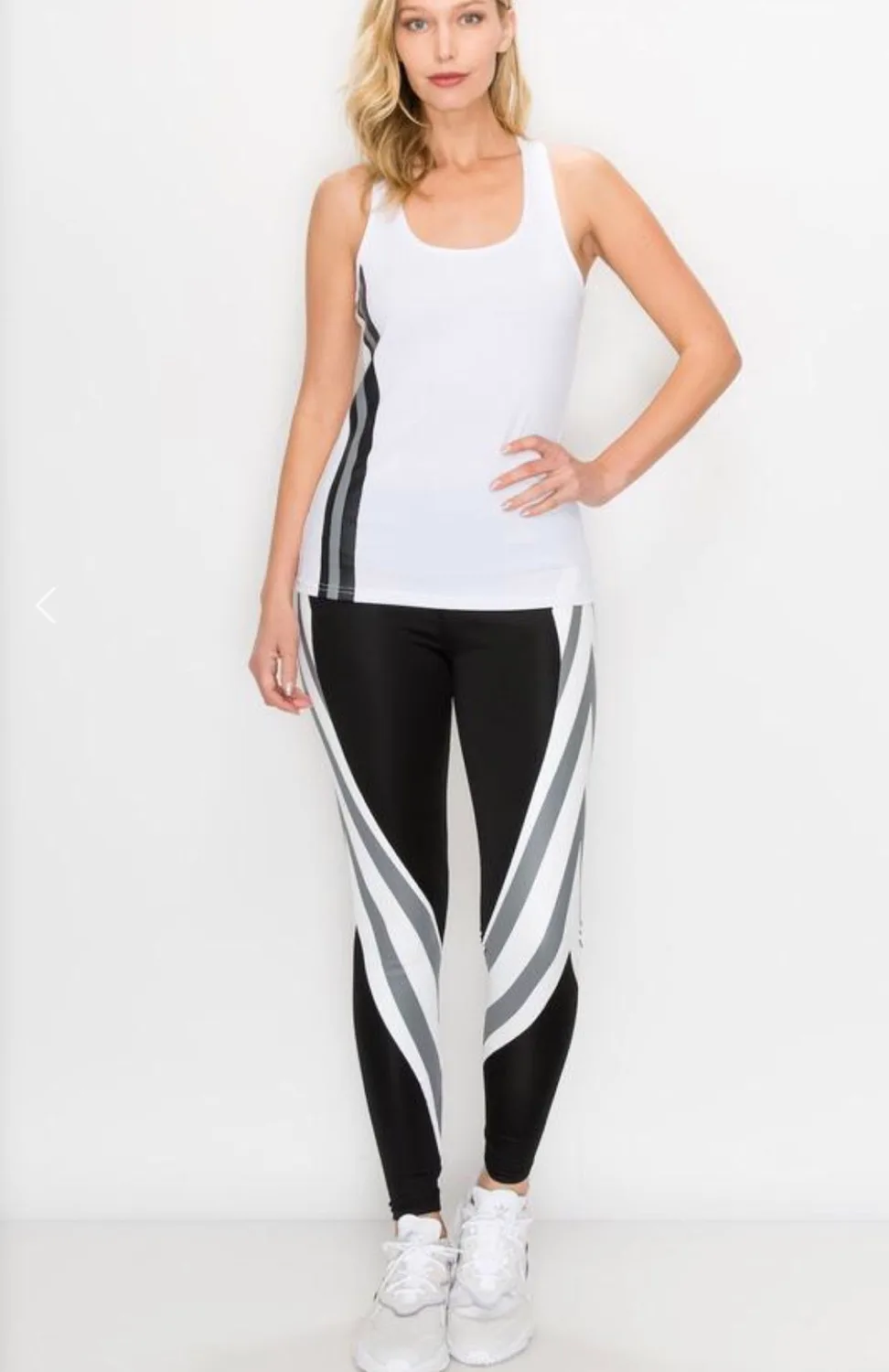 Woman in white athletic tank top and patterned leggings