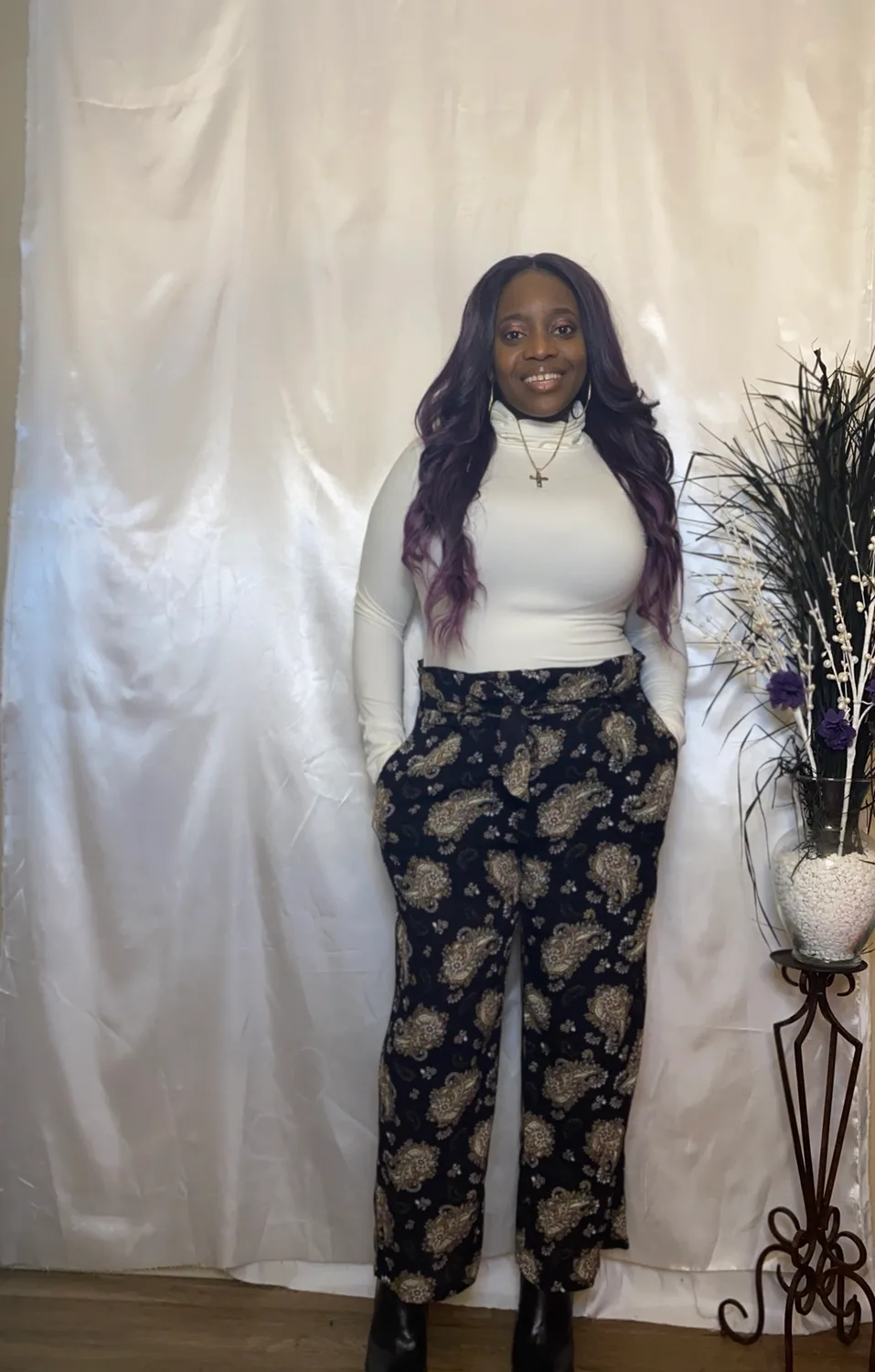 Smiling woman in white top and patterned pants